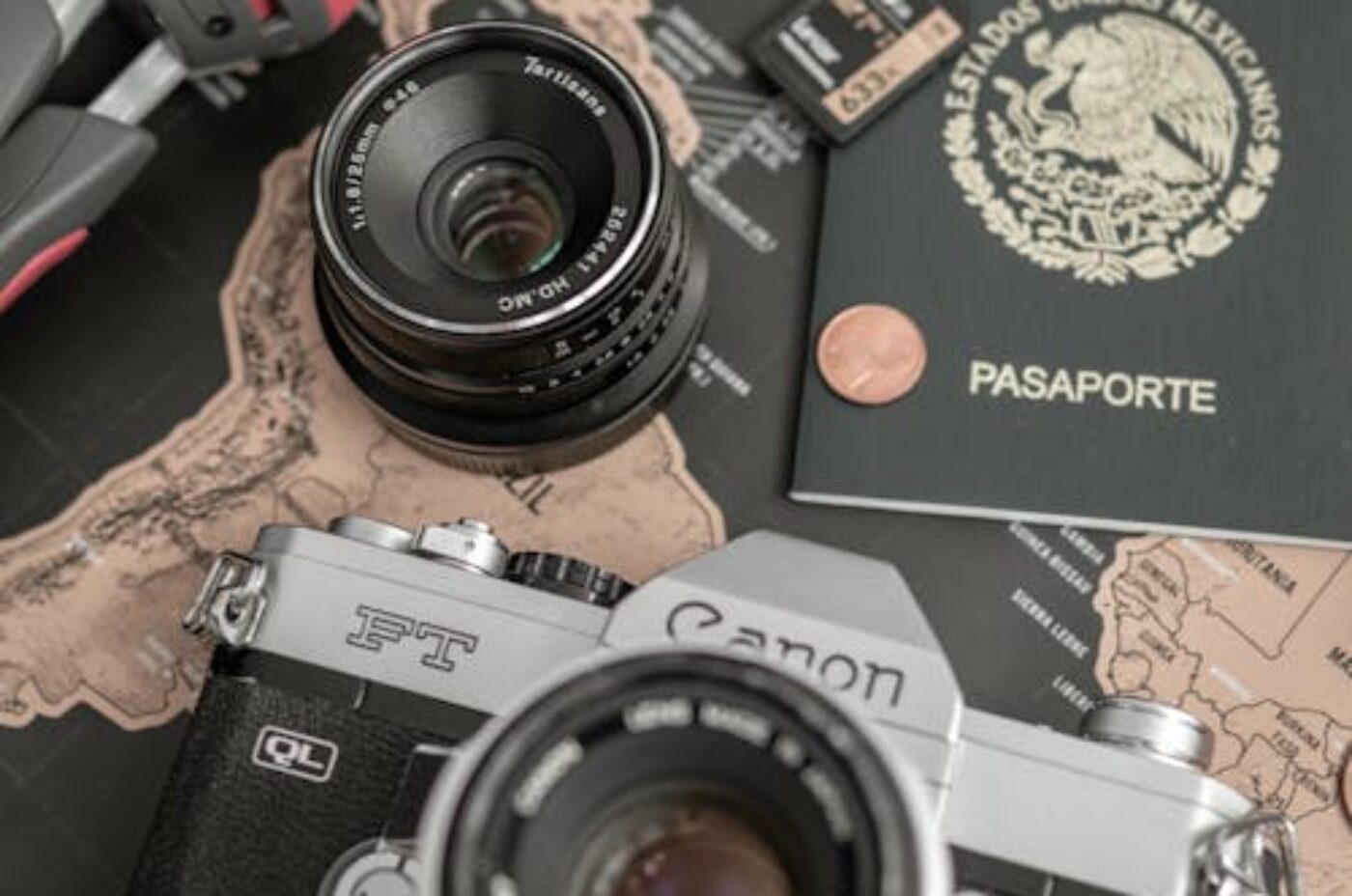 Camera, passport and map on table — planning a Madagascar trip budget