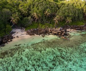 Aerial view of a tropical island coastline with turquoise water