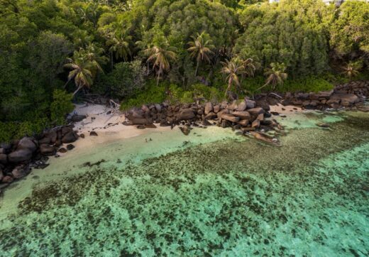 Aerial view of a tropical island coastline with turquoise water