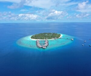 Aerial view of a private island resort with turquoise waters in the Indian Ocean