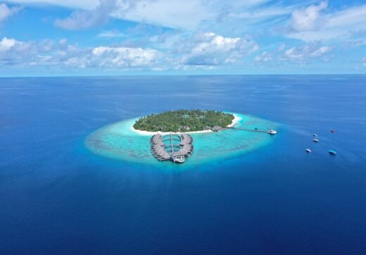 Aerial view of a private island resort with turquoise waters in the Indian Ocean