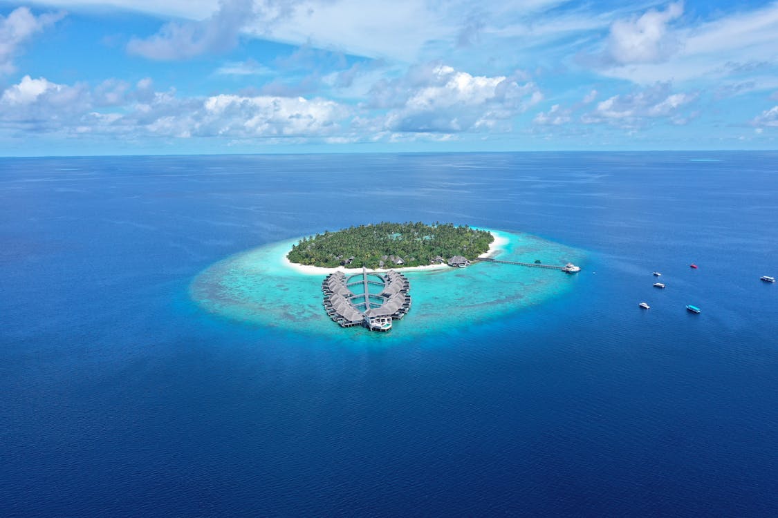 Aerial view of a private island resort with turquoise waters in the Indian Ocean