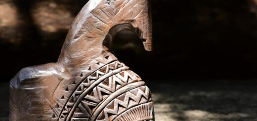 Madagascar wooden statue souvenirs — Close-up of a hand-carved wooden horse sculpture with tribal patterns, capturing natural light and shadows.