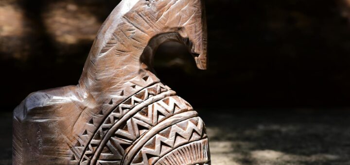 Madagascar wooden statue souvenirs — Close-up of a hand-carved wooden horse sculpture with tribal patterns, capturing natural light and shadows.