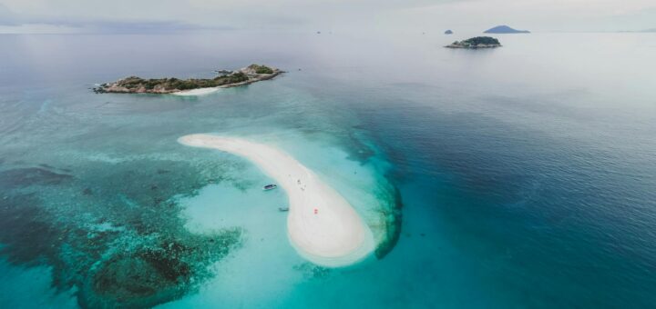 Stunning aerial photo of tropical islands and sandbar with clear blue water.