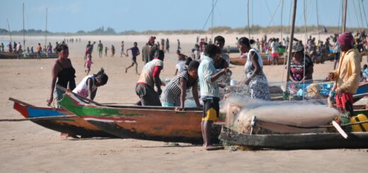 Vezo fishermen working with their colorful traditional pirogue boats on a Madagascar south coast beach