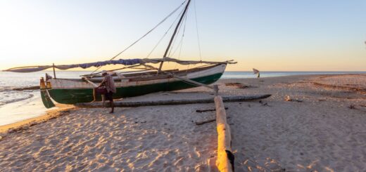 A traditional outrigger pirogue on a Madagascar beach at sunset